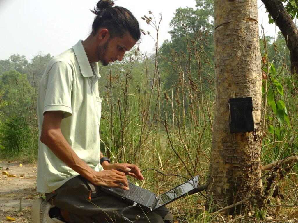 Ram Raj Dhakal (Nana) checking camera trap images in the community forest.