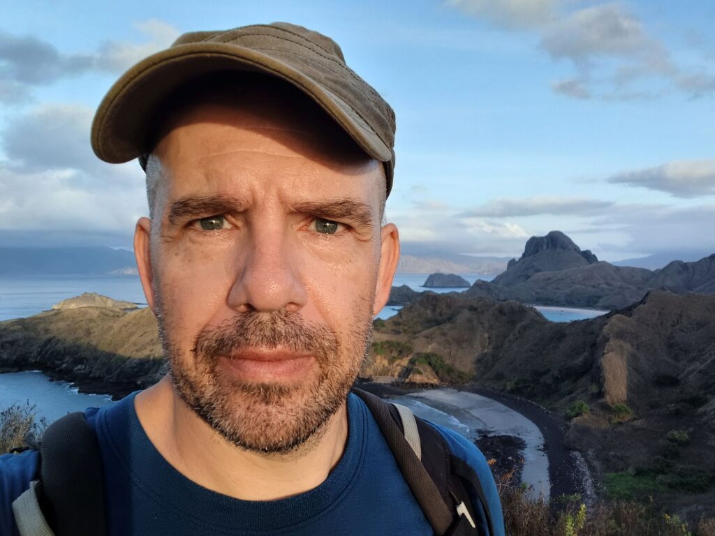 Myself, with Padar Island at sunrise behind